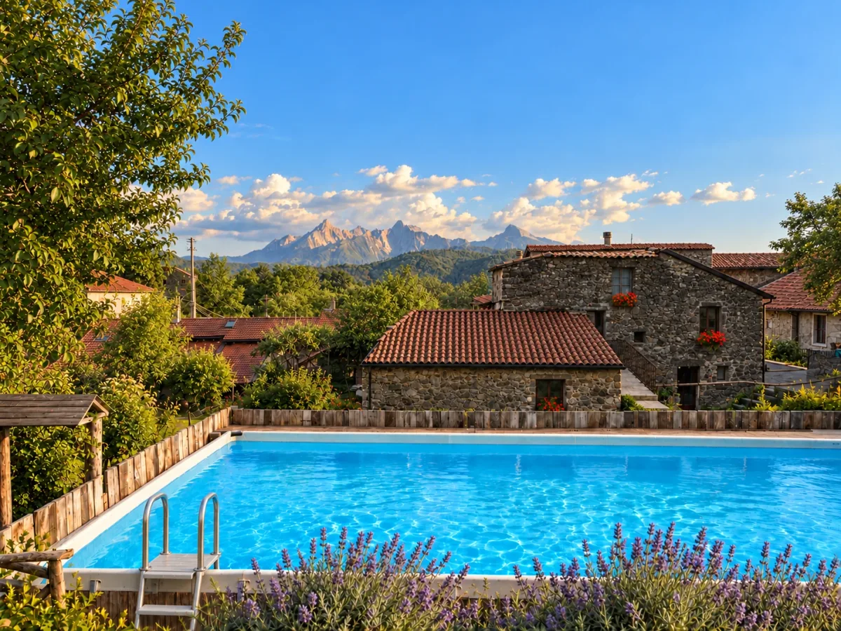 Pool, stone houses and the Apuan Alps at Quarazzana in Lunigiana
